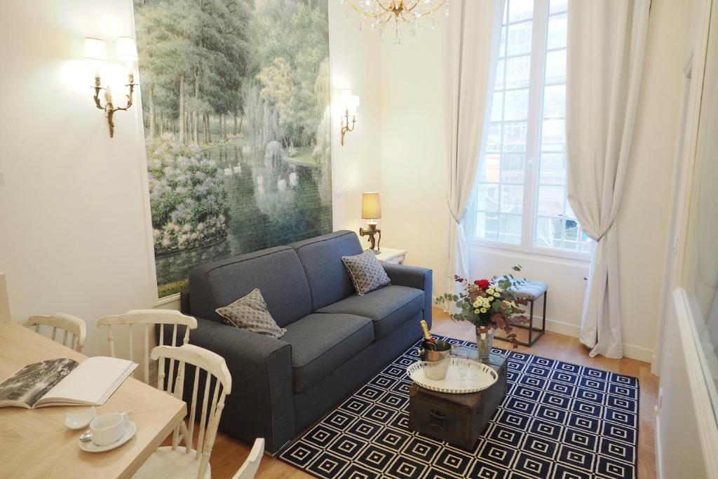 パリにあるルーヴル オペラ デザイン シックスイーツのリビングルーム(青いソファ、テーブル付)