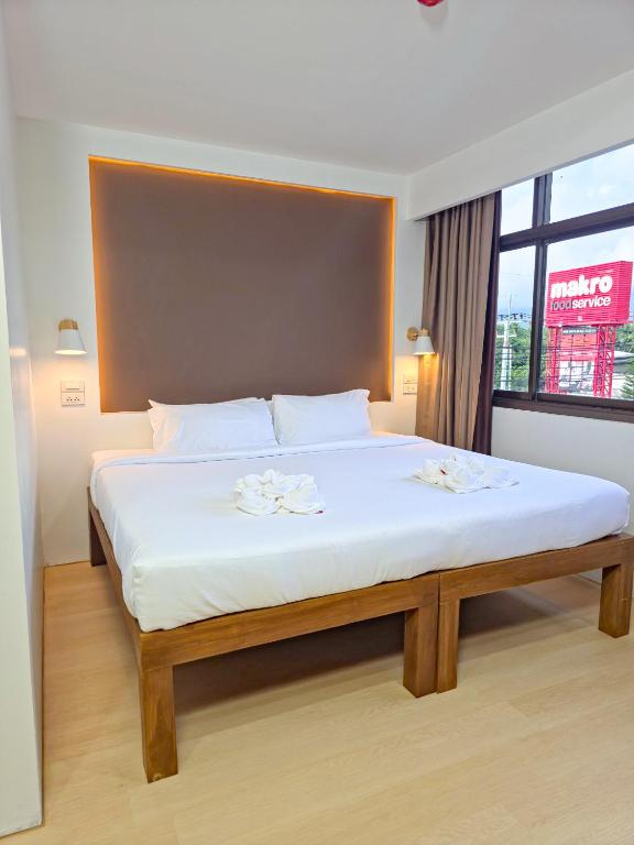 ein großes Bett in einem Zimmer mit Fenster in der Unterkunft SANDB Hotel in Ko Phangan