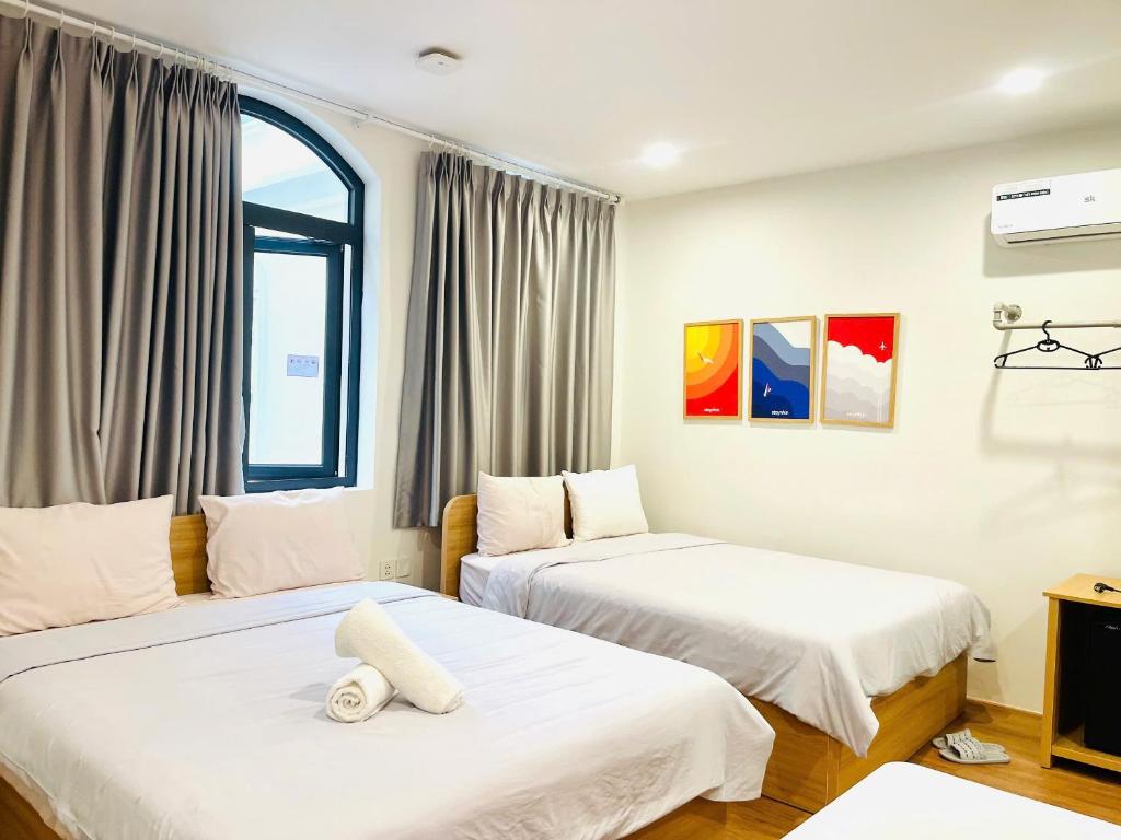 a room with two beds and a window at Thanh hoa HOMESTAY in Hòa Bình