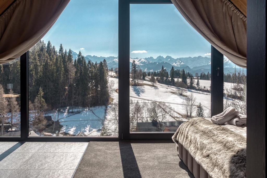 a bedroom with a view of a snow covered mountain at RzepiskaView in Rzepiska