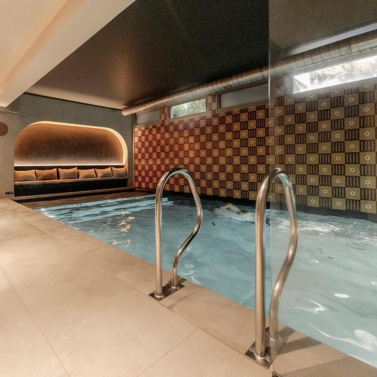 a swimming pool with a hot tub at Hôtel Pilgrim in Paris