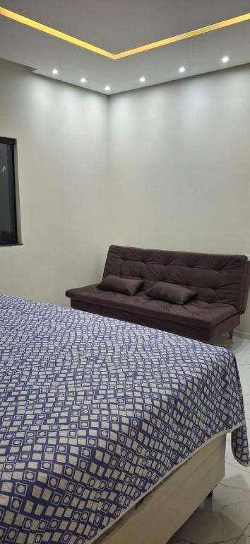 a bed in a room with a couch against a wall at SSP Ubajara in Ubajara