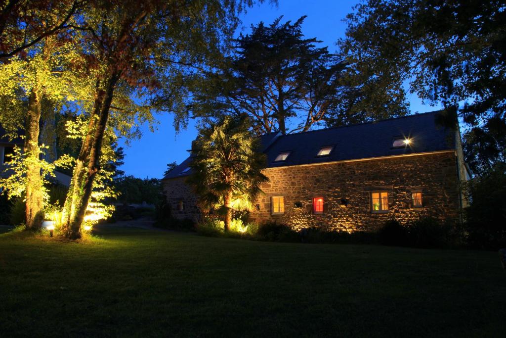 una casa de piedra con luces de Navidad en el patio en Gîte de Guernevez, en Hôpital-Camfrout