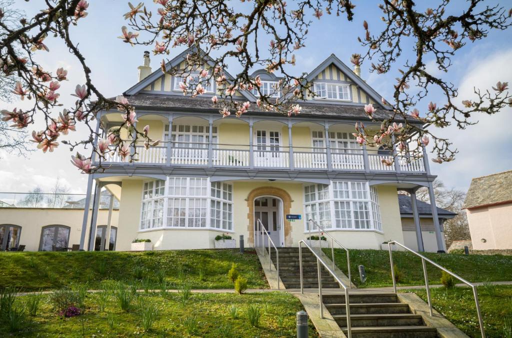 a large white house with a staircase in front of it at Northgate House in Buckfastleigh