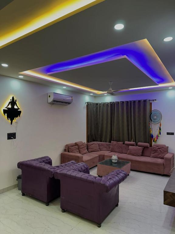 a living room with two couches and a blue light at Hacienda napoles in Chandigarh Airport