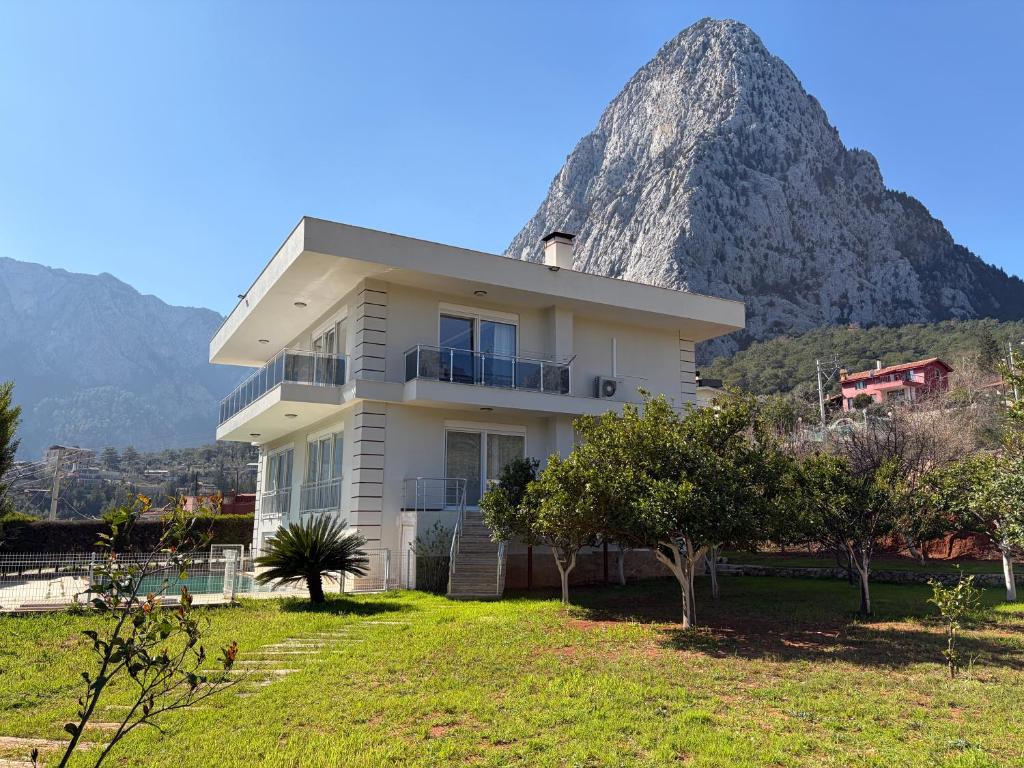 a white house with a mountain in the background at Villa Leom - Mountain Villa with Pool in Antalya in Gedeller