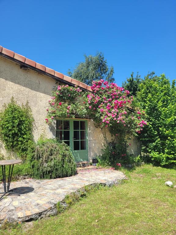 a building with a window with pink flowers on it at Studio cosy au calme in Chillac