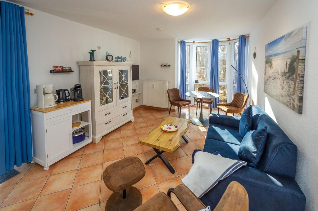 a living room with a blue couch and a table at Fewo Strandallee - Baabe in Baabe