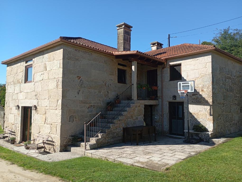 a small stone house with a basketball hoop at Casa San Son in Pontevedra