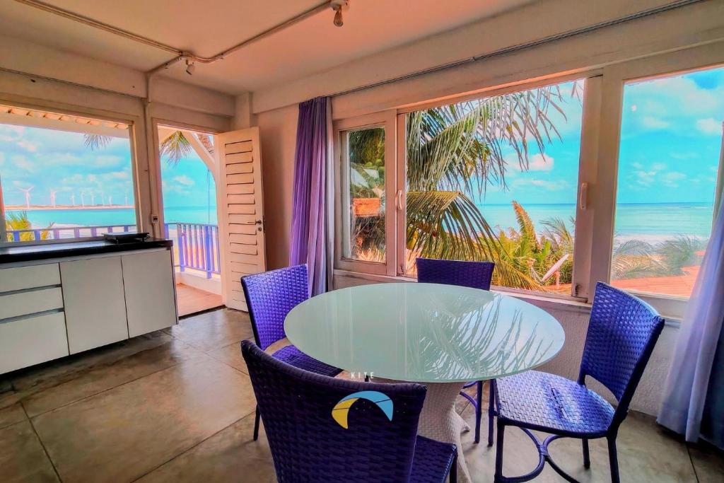 a dining room with a table and chairs and the ocean at Saint Germain Kite Residence in Icaraí