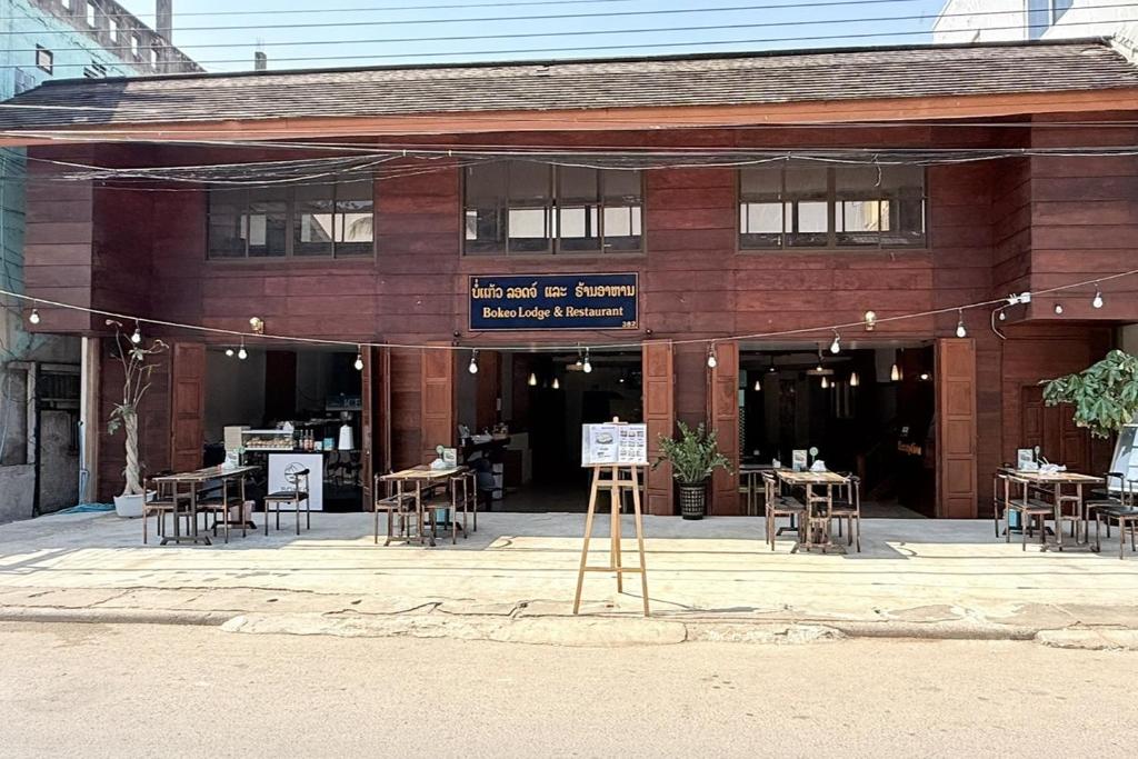 a building with tables and chairs in front of it at Bokeo Lodge & Restaurant in Ban Houayxay