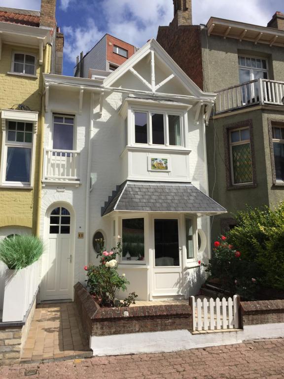 a white house with a white front door at Maison No Catiau - De Panne in De Panne