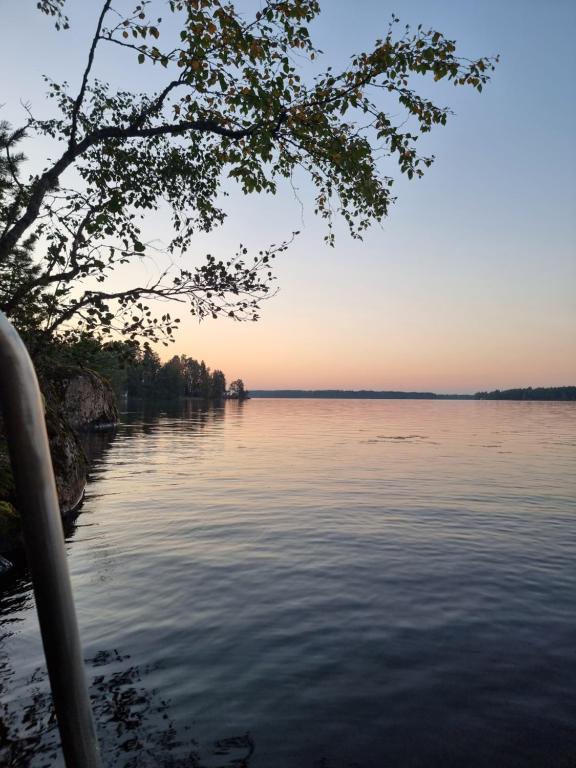 a view of a body of water at sunset at Narvijärven lomamökki in Rauma