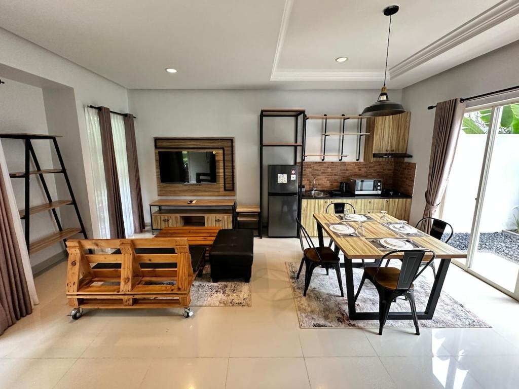 a kitchen and dining room with a table and chairs at Timber Sanctuary at Rancamaya in Ciawi Bogor