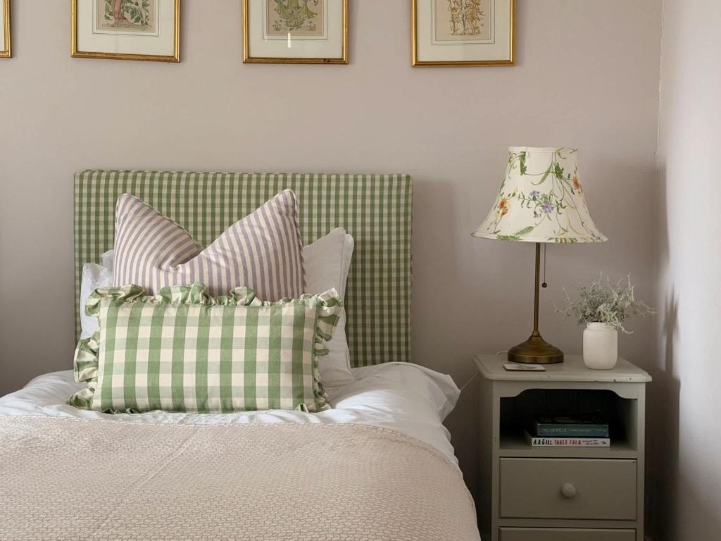a bed with a pillow and a lamp on a night stand at The View Cottage - Tennis Court - Nr Frome, Longleat in Frome