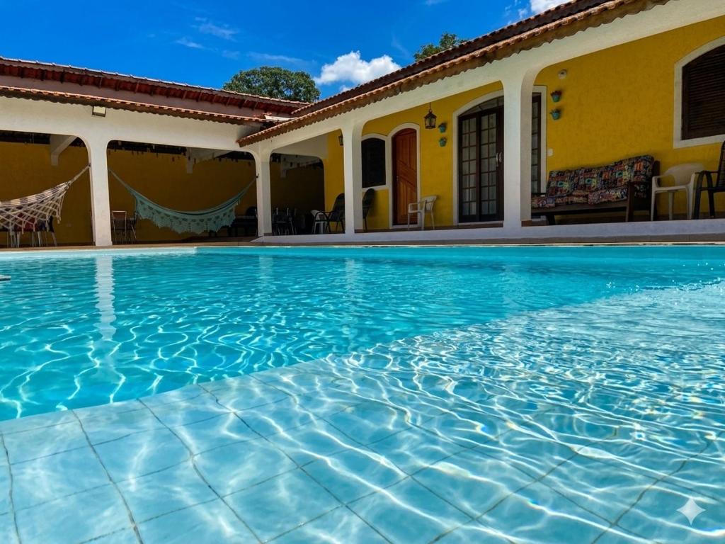a swimming pool in front of a house at Pousada casa amarela Analândia SP in Analândia