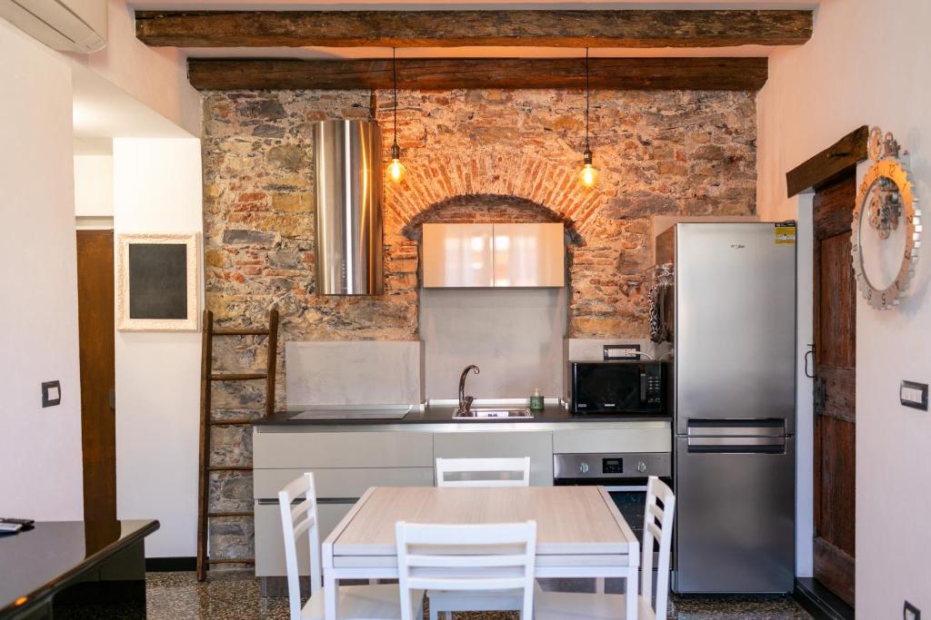a kitchen with a table and a brick wall at Trilocale Luxury - 5 minuti Acquario di Genova in Genoa
