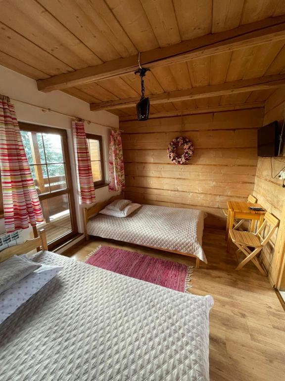 a bedroom with two beds in a log cabin at Pokoje u Kalaty in Szaflary