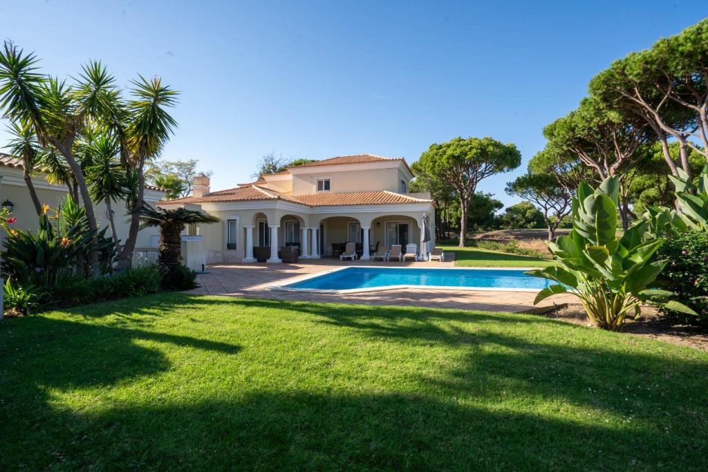 a house with a swimming pool in a yard at Casa Atlantico in Quinta do Lago