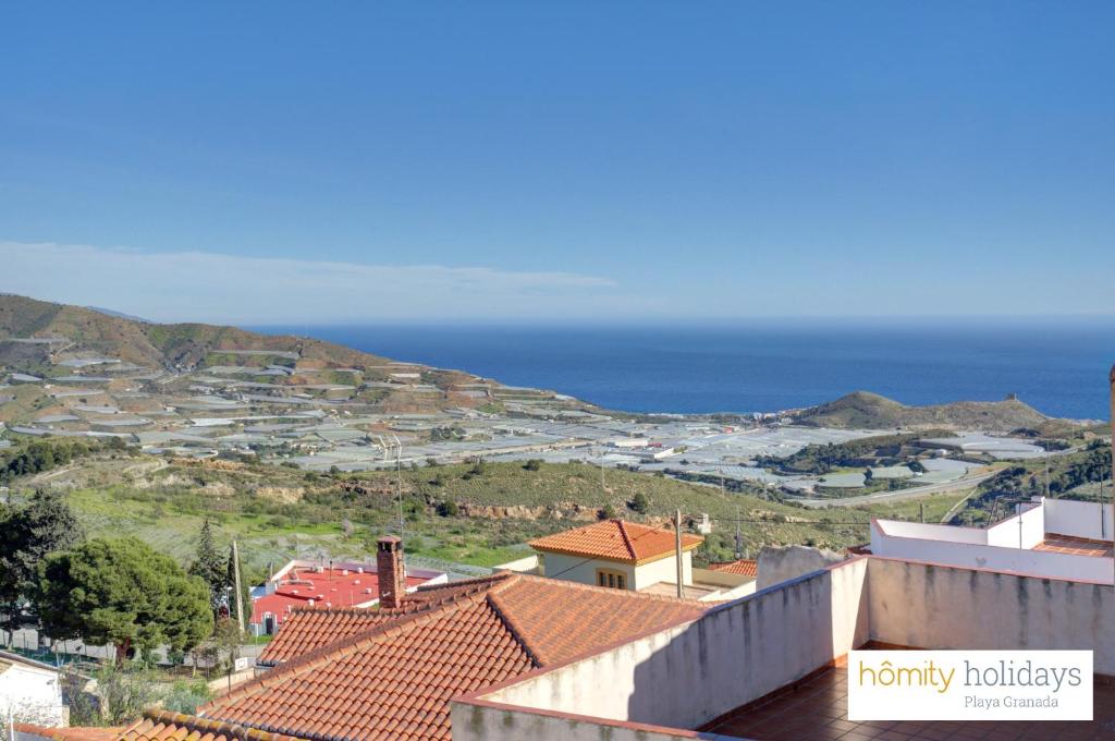 a view of a town with the ocean in the background at Homity Holidays - Gualchos - Casa Río Oculto in Gualchos