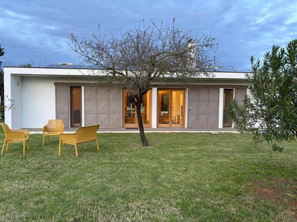 a house with two chairs and a table in a yard at Casa Vacanza 2 Mari in Alghero
