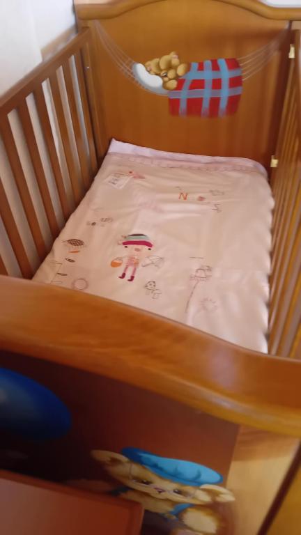 a crib with a blanket on top of it at Vasiliki in Dhílesi