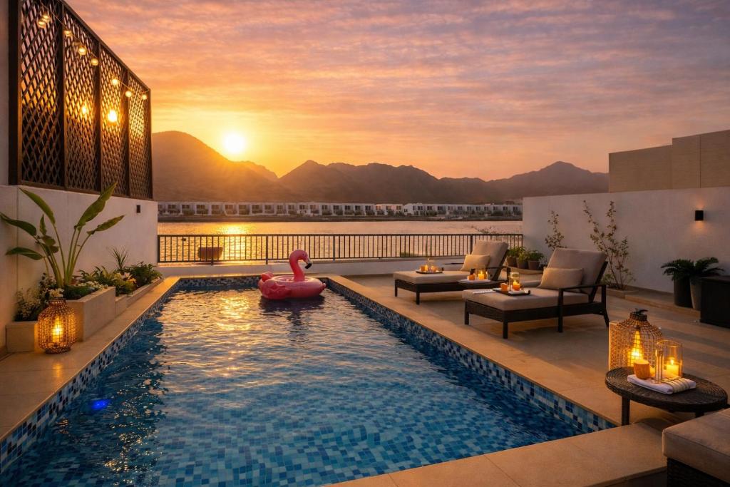 a pool on the roof of a building with a sunset at Seascape Villa Marine in Fujairah