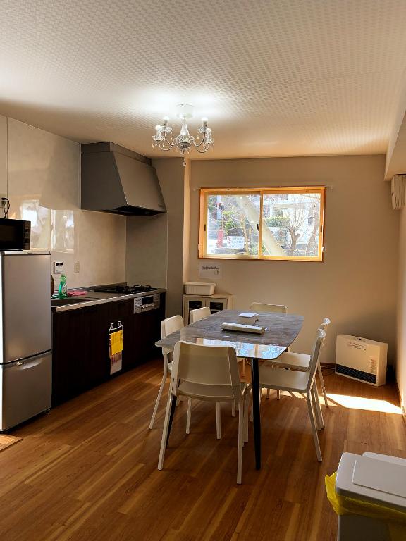 a kitchen and dining room with a table and chairs at 竹の宿b湖まで徒歩4分の好立地最大7人宿泊可能 in Fujikawaguchiko