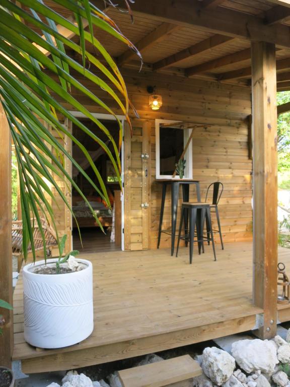 a wooden cabin with a table and chairs on a deck at Cabane Autentikaz in Saint-François