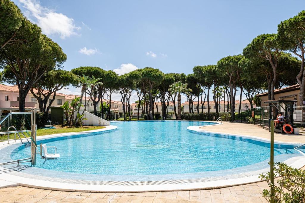 a large swimming pool with trees in the background at Balconera 104 in Novo Sancti Petri