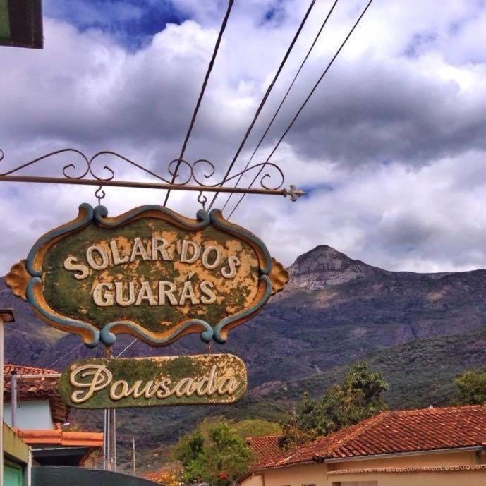 a sign for a restaurant in front of a mountain at Pousada Solar dos Guarás in Catas Altas