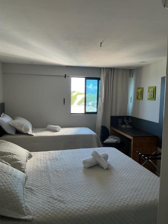 a hotel room with two beds with towels on them at Apartamento 1307 QUALITY HOTEL in Natal