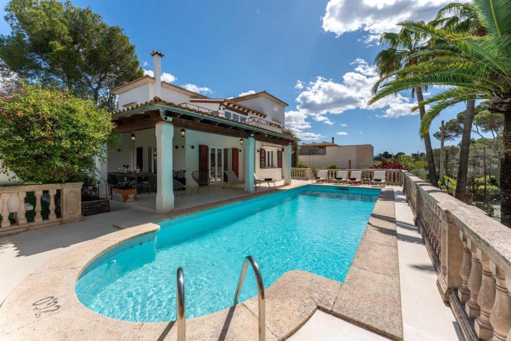 a swimming pool in front of a house at Casa Baskings in Portopetro