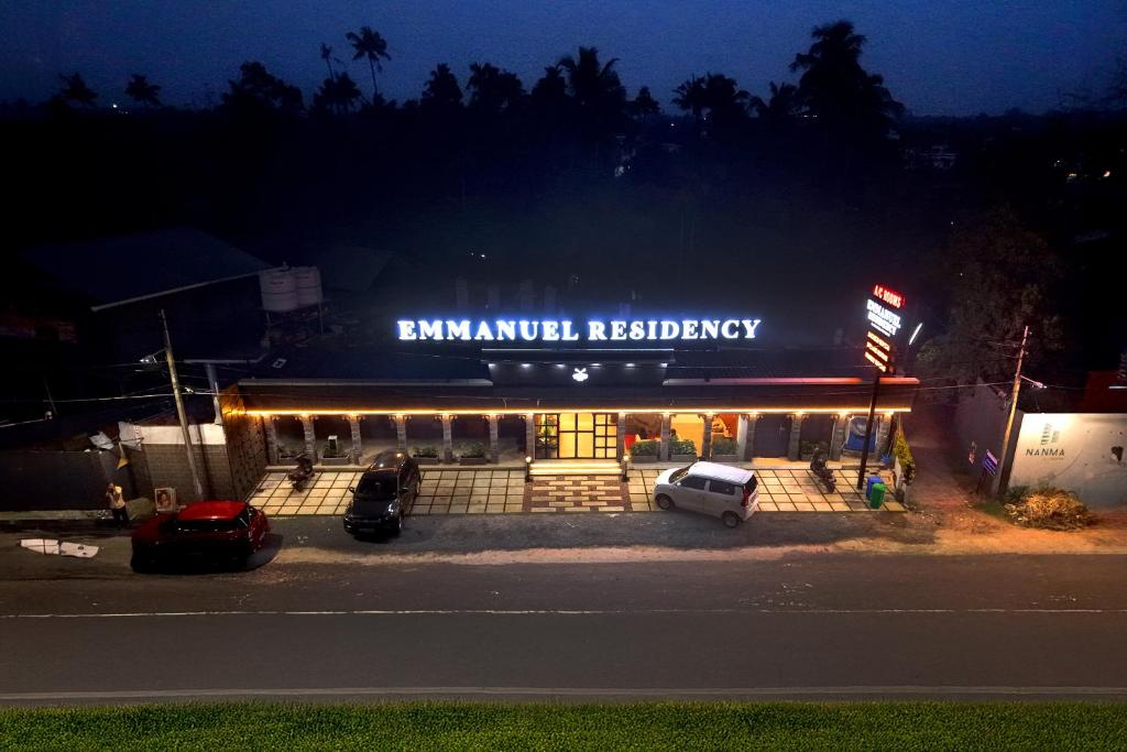 a building with a car parked in front of it at Emmanuel Residency in Edappally