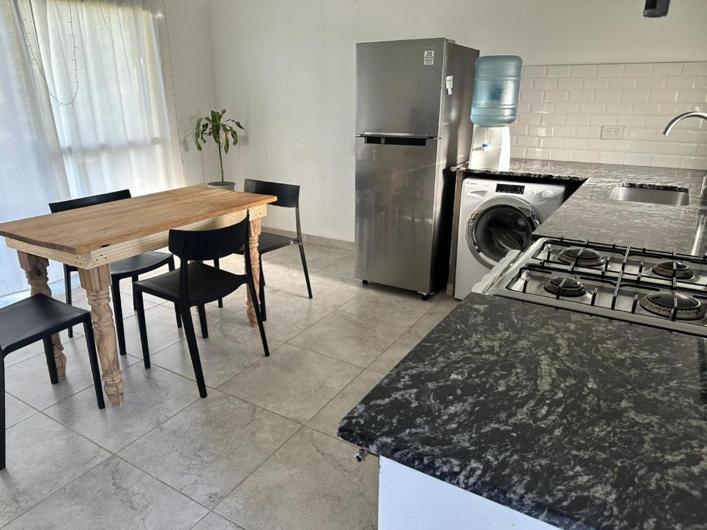 a kitchen with a wooden table and a stove at Departamento y aire libre in General Pico