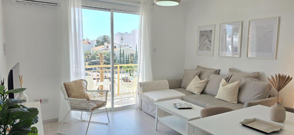 a white living room with a couch and a table at White Aura by Staycom in Paphos