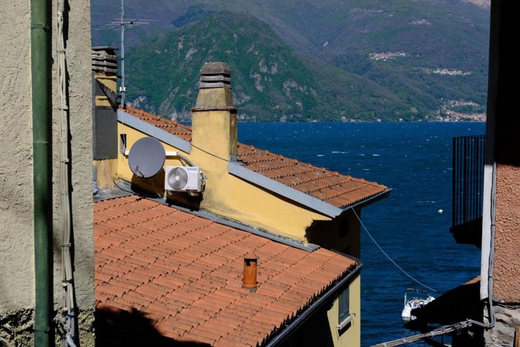 a view of a building with a view of the water at La casa dei Percy in Varenna