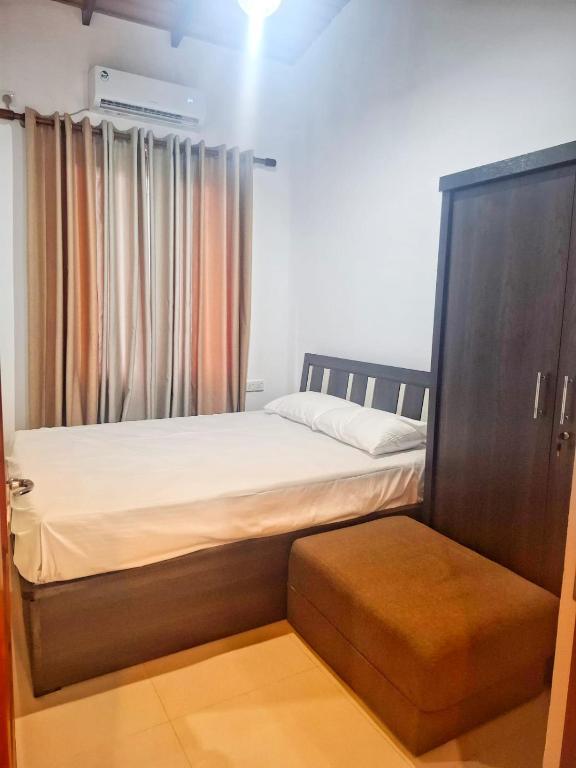 a small bedroom with a bed and a cabinet at Banana Leaf Villa in Nikawatawana
