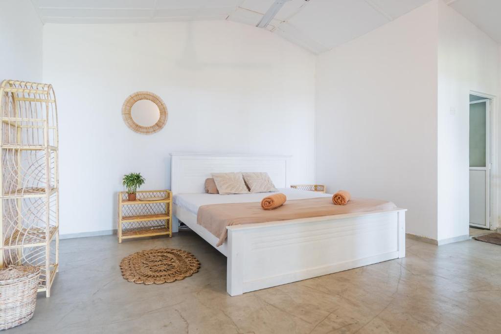 a white bedroom with a bed with a wooden headboard at Naïa Ocean House Midigama in Midigama West