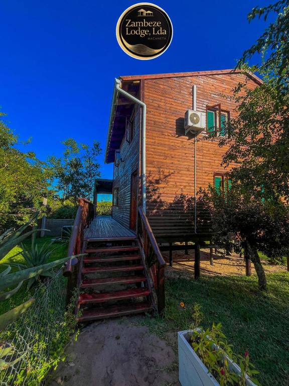 a house with stairs leading up to a building at Zambeze Lodge in Marracuene