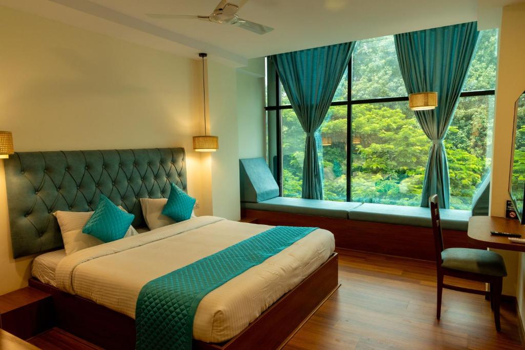 a bedroom with a large bed and a window at Joven's central hotel in Bangalore