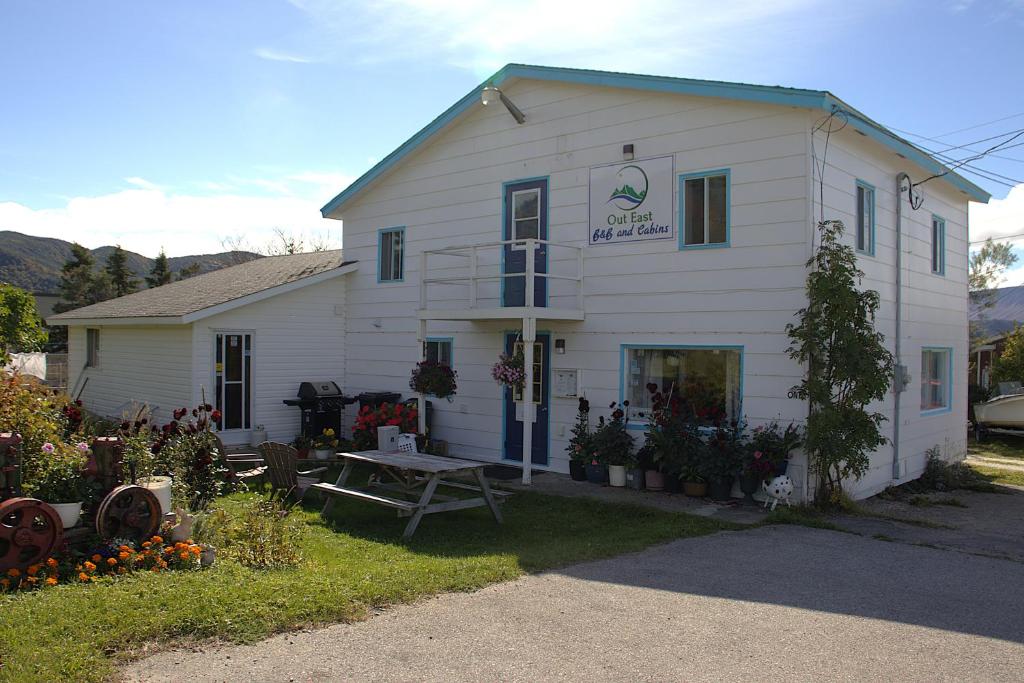 a white house with a picnic table in front of it at Out East B&B - Norris Point in Norris Point