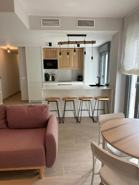 a living room with a couch and a kitchen at ABA Malaguita in Conil de la Frontera