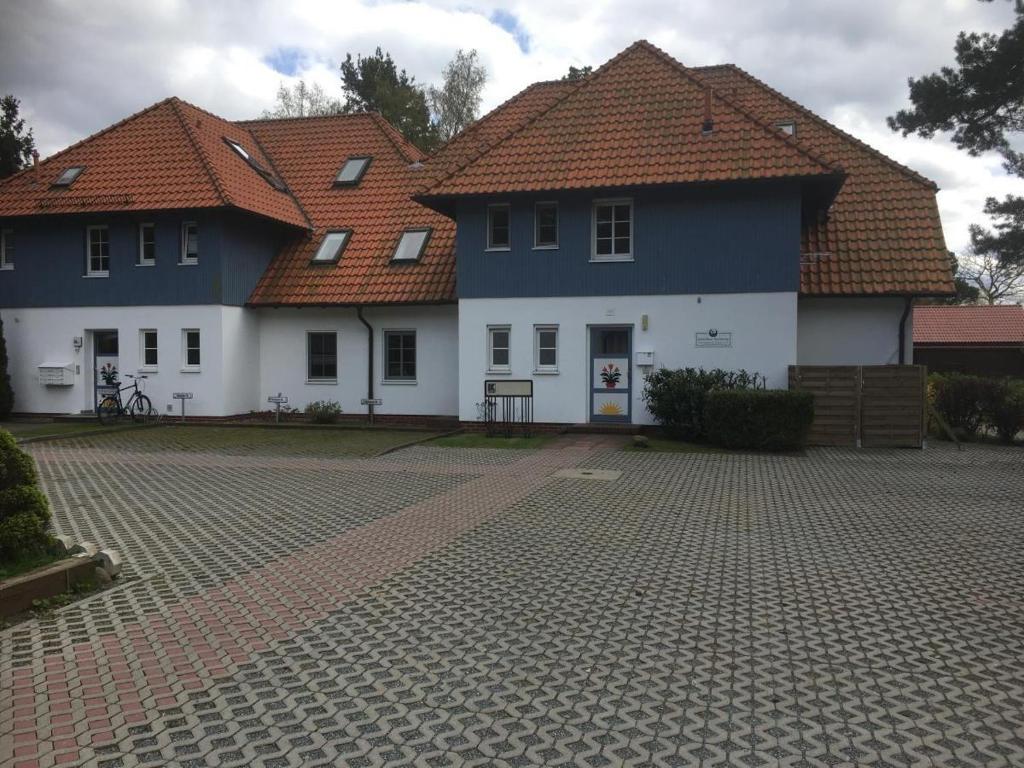 two houses with red roofs on a brick road at Gaestehaus-W-13 in Prerow