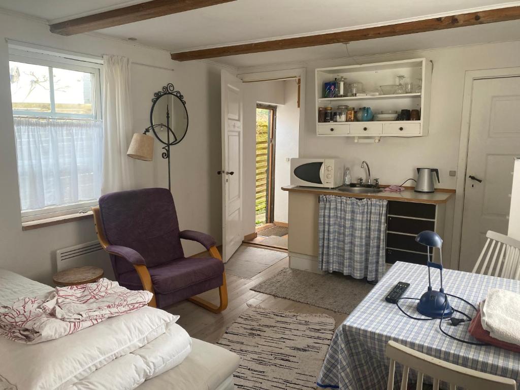 a living room with a table and a chair at City gæstehus kerteminde in Kerteminde