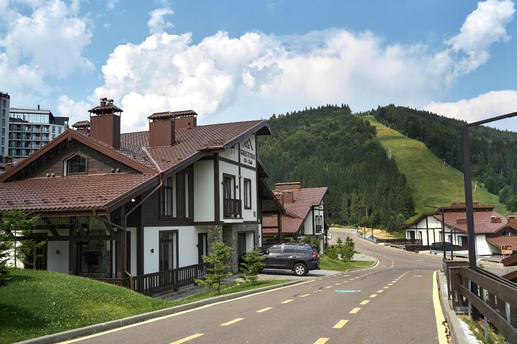 a house on the side of a street with a hill at Greitser Elit Chalet in Bukovel