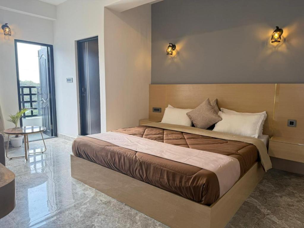 a bedroom with a large bed and a table at The Notting Hills Inn in Shillong