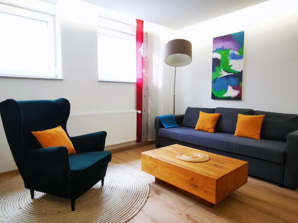 a living room with a blue couch and a coffee table at Gemütliches Souterrain in Langenargen in Langenargen