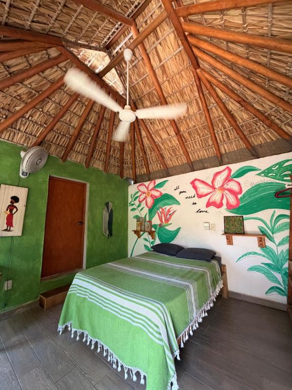 a bedroom with a bed and a ceiling fan at CASA AUM in Brisas de Zicatela