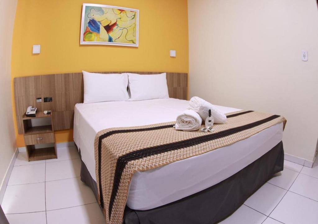 a bedroom with a large bed with towels on it at Boulevard Park Hotel in São Luís